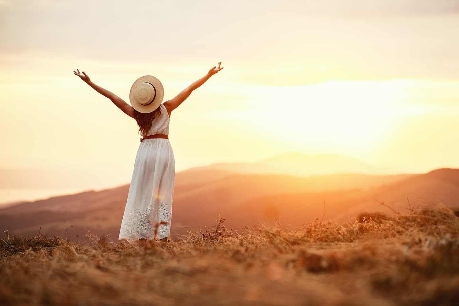 Happy person in field looking off into sun