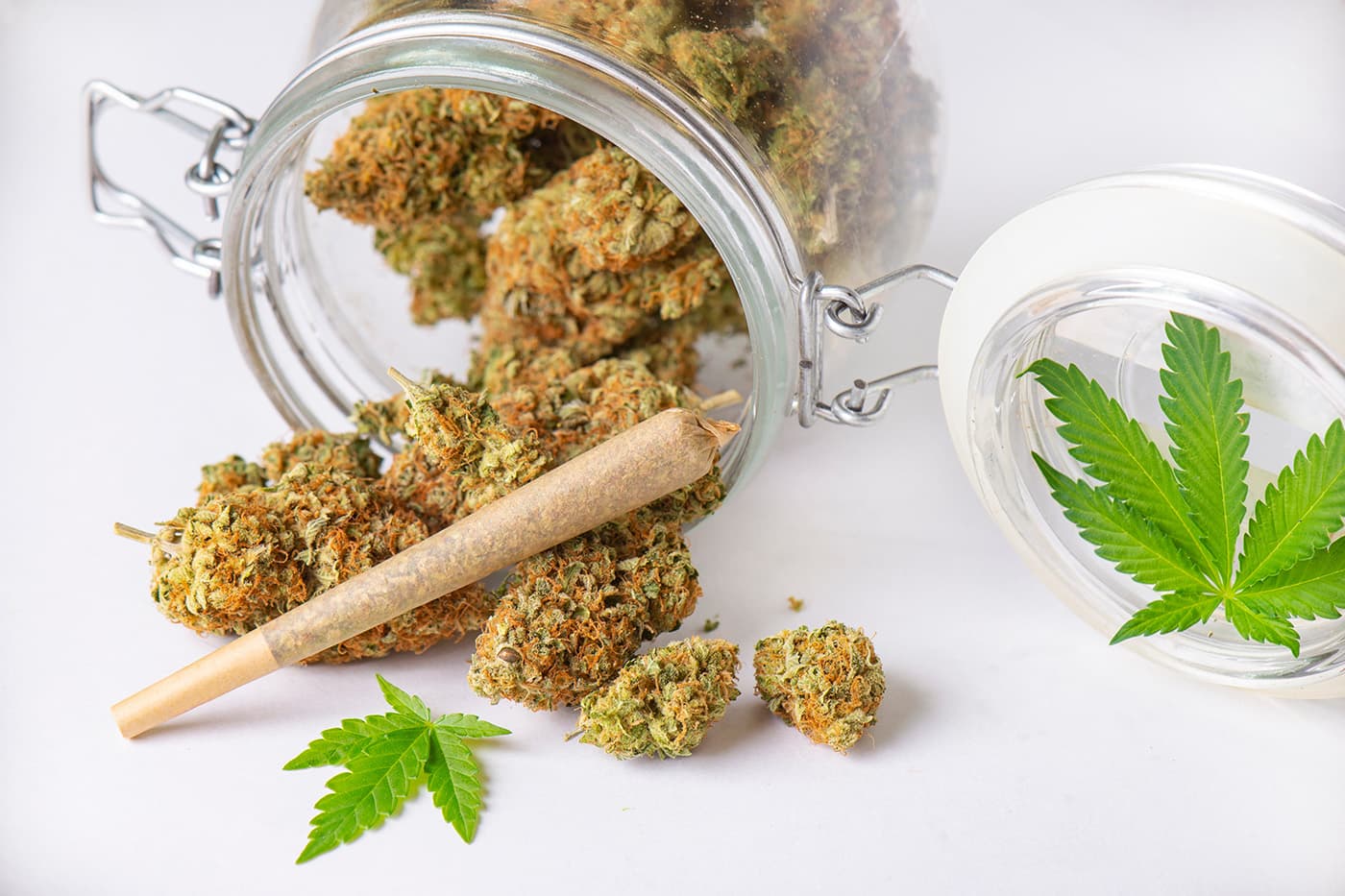 Delta 8 pre roll and delta 8 flower in jar on white table