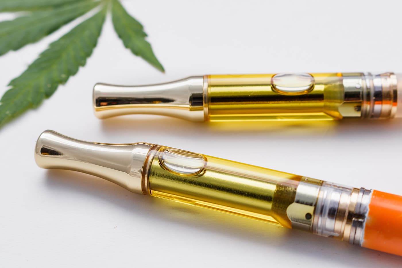 Two delta 8 THC vape pens on table with white background
