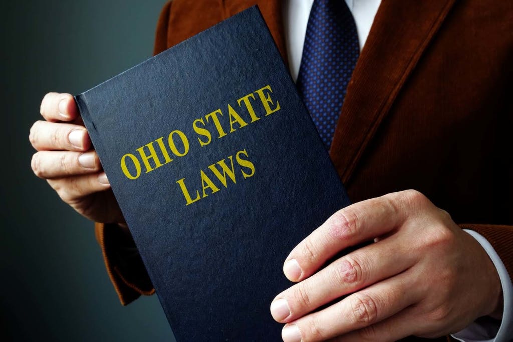 Book of Ohio state laws being held by person