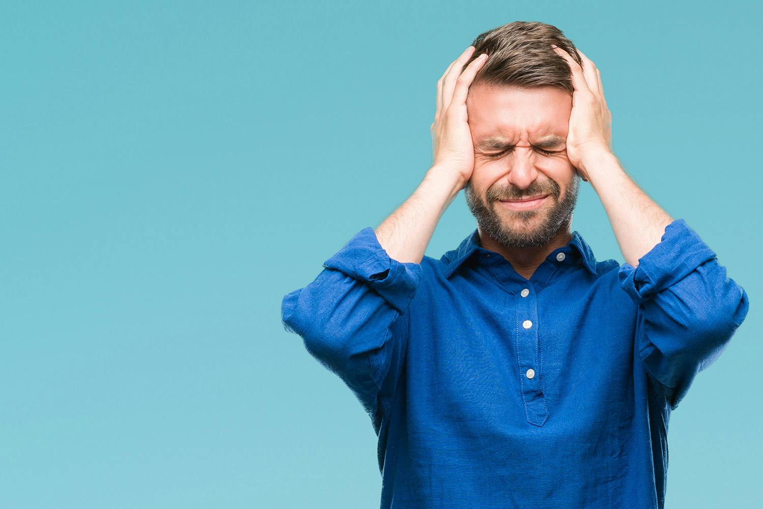 Man with migraine on blue background