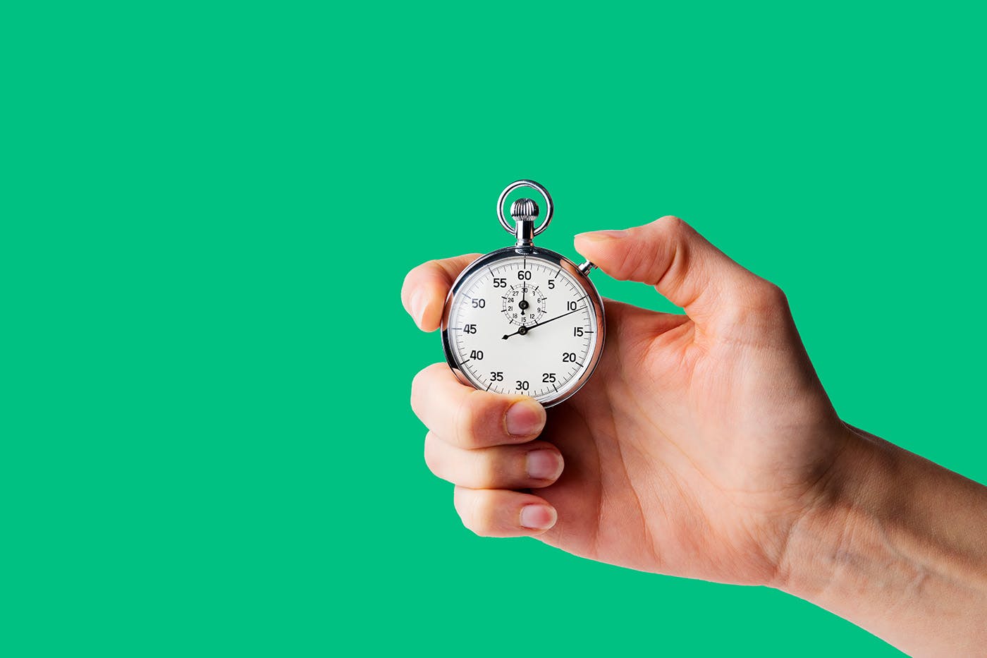 Person holding stopwatch on green background