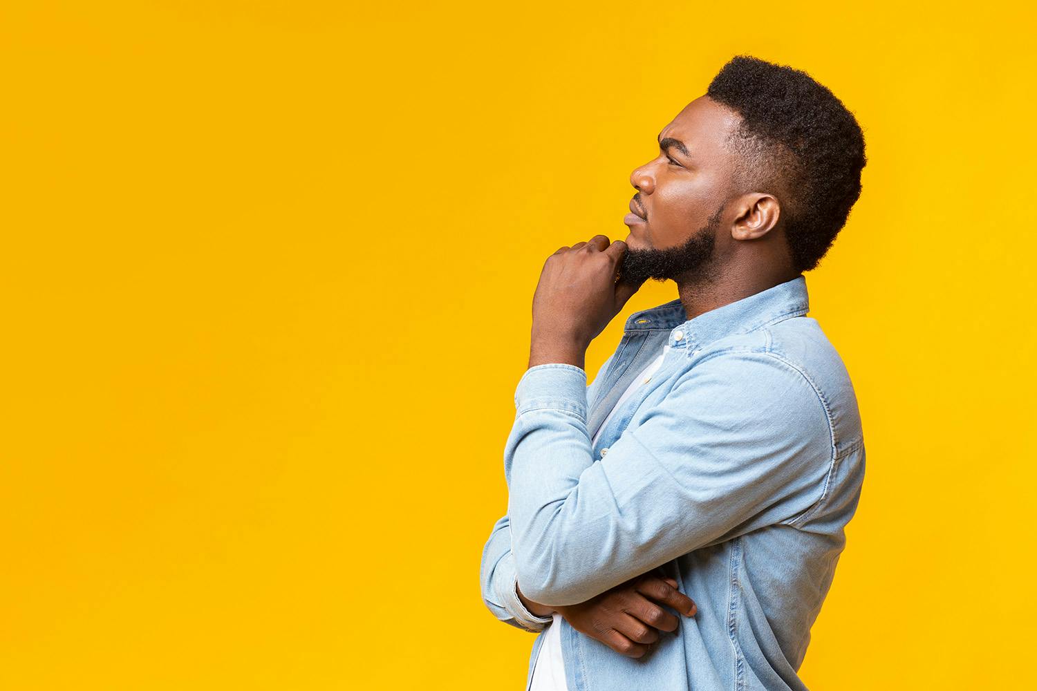 Man thinking looking to the stage right on yellow background